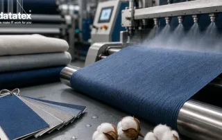 Textile finishing machine processing blue fabric with fabric samples and cotton in the foreground